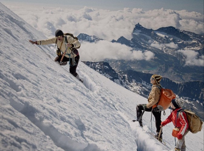 Three people climbing a snow-covered mountain