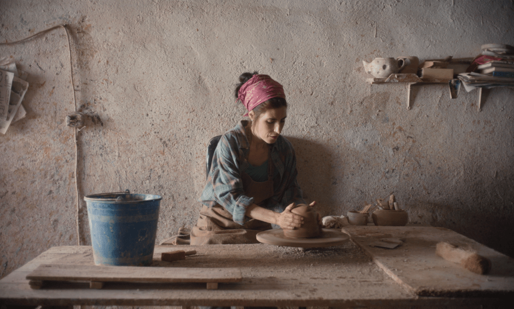 A woman using a potter's wheel to create pottery